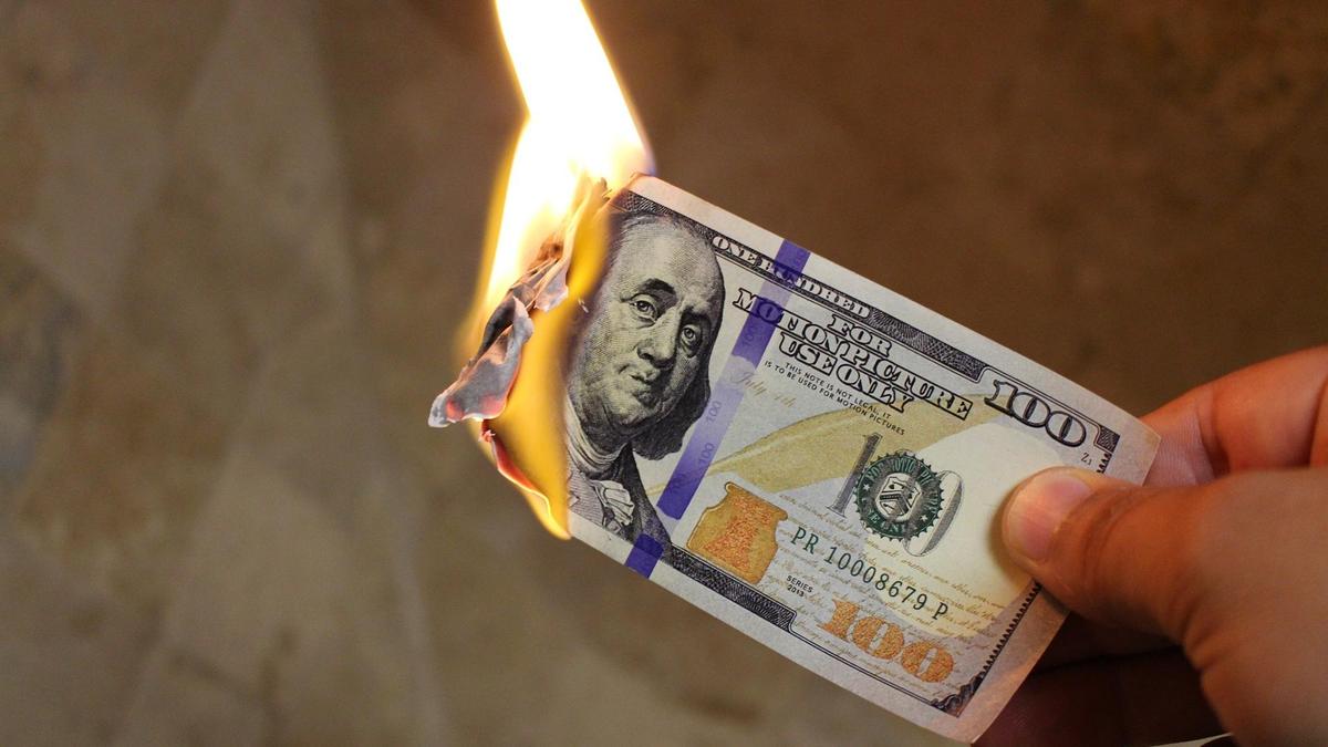 100 долларов сгорают в руке
