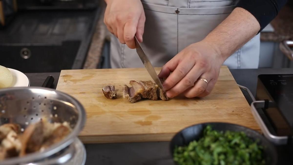 Мясо с говяжьих ребер нарезают на разделочной доске