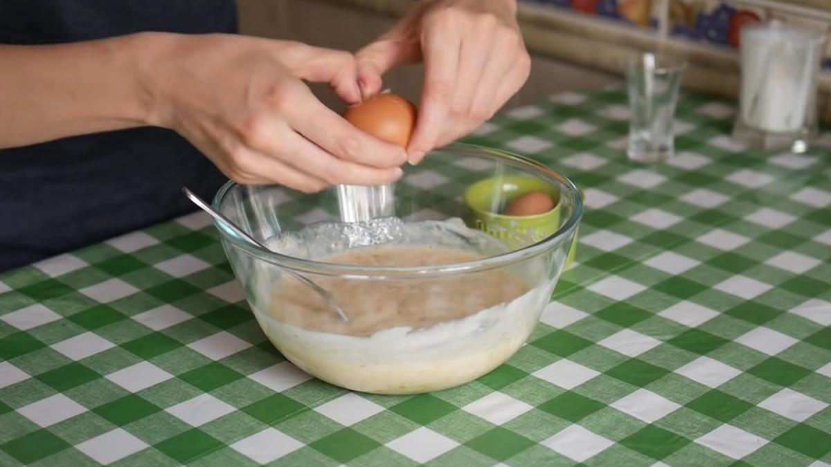 В миску с тестом разбивают куриное яйцо