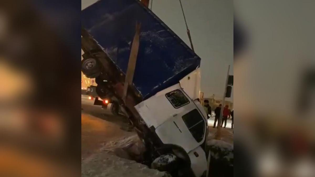 Грузовик вытаскивают из ямы при помощи спецтехники