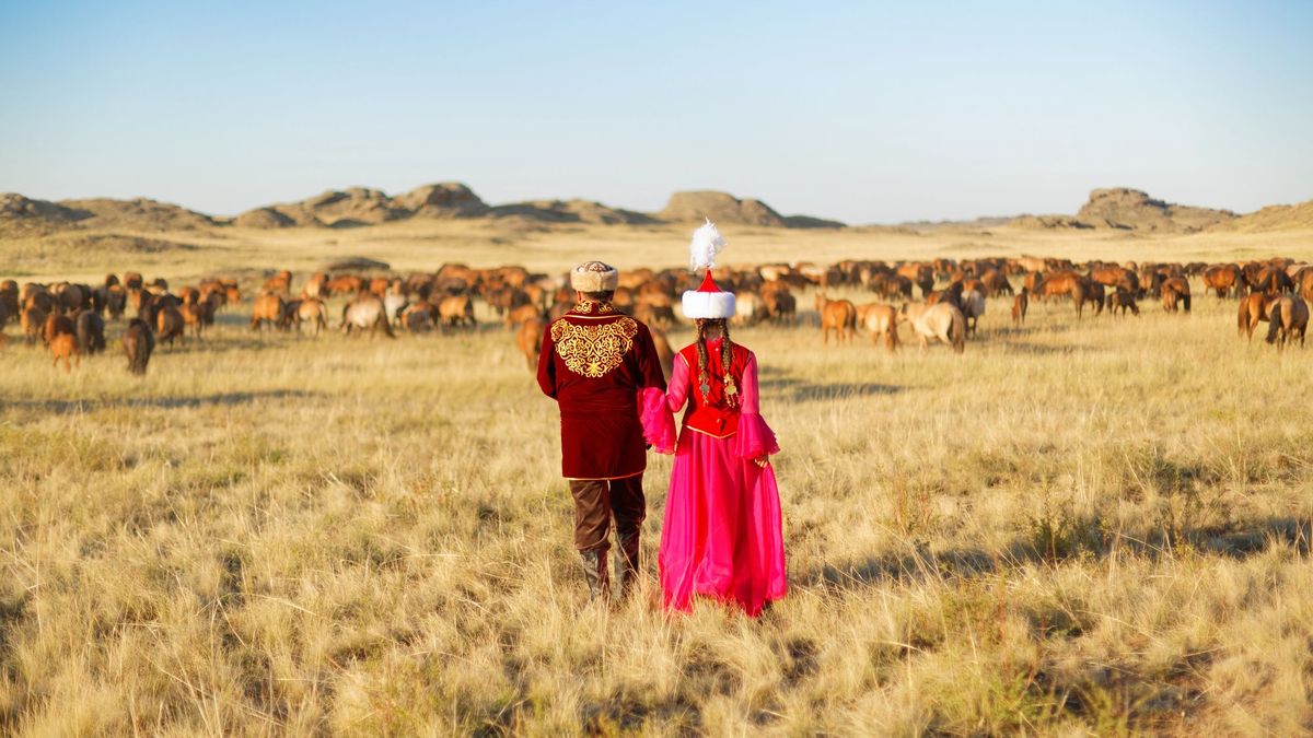 мужчина и женщина в национальных костюмах в степи