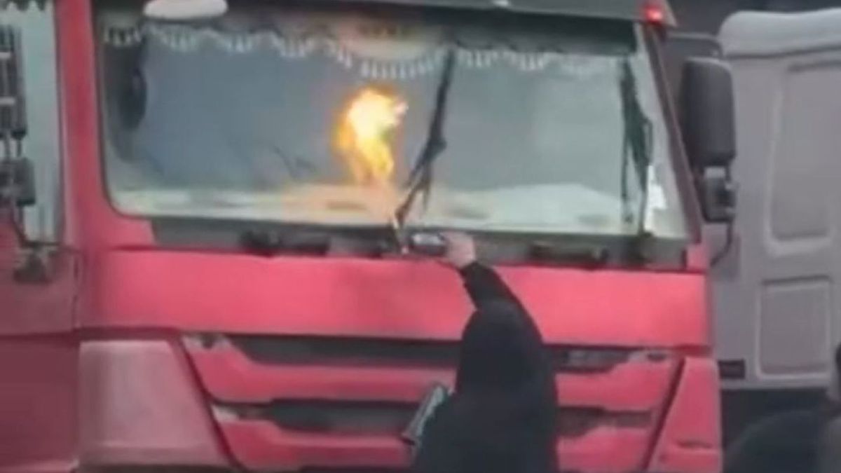 Мужчина отогревает стекло газовой горелкой