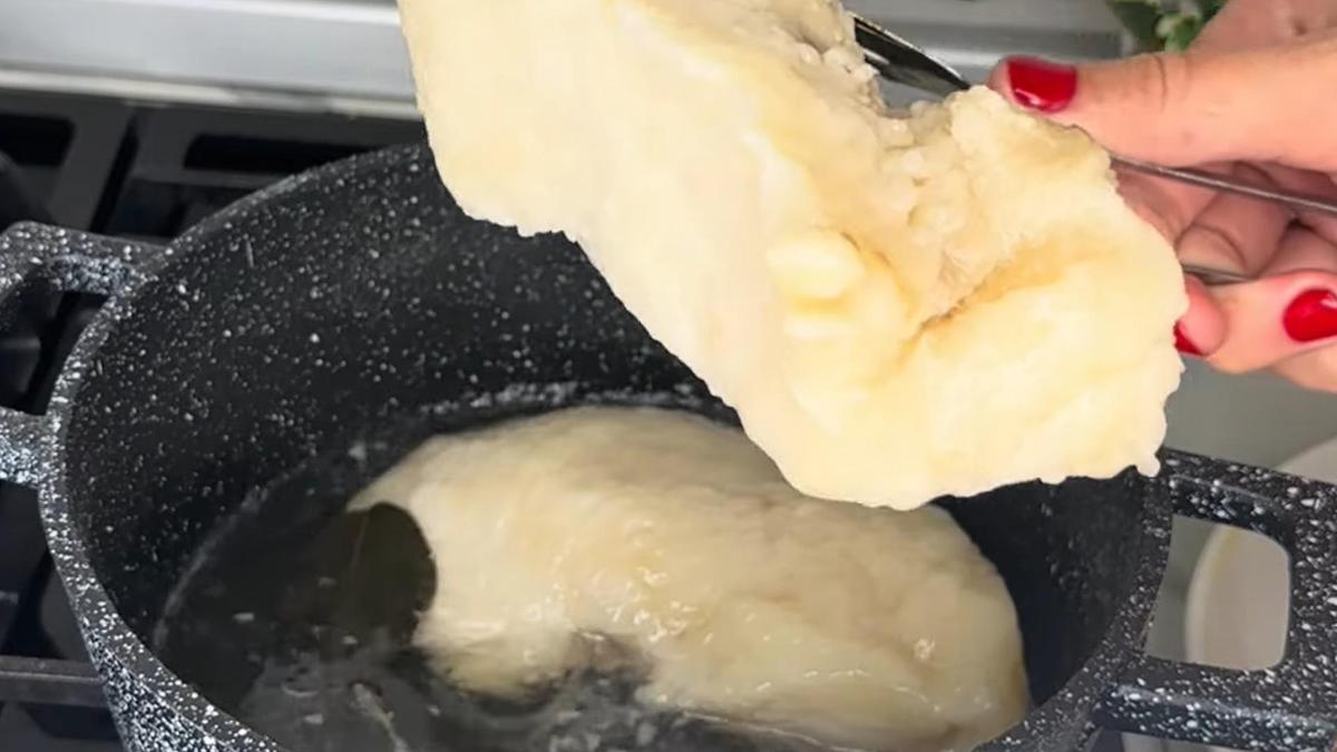 Из кастрюли достают щипцами сваренный курдючный жир