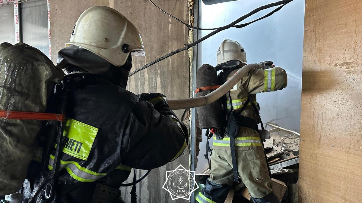 Өрт сөндіріп жатқан өрт сөндірушілер