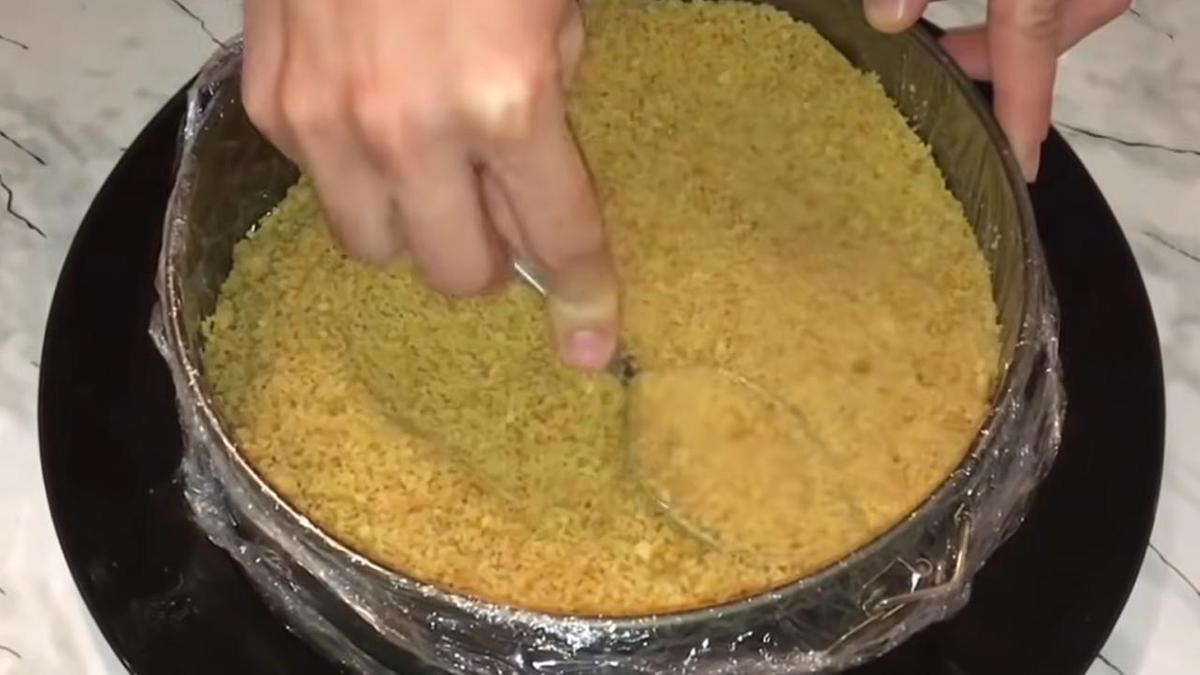 В форме ложкой утрамбовывают песочную основу на чизкейк