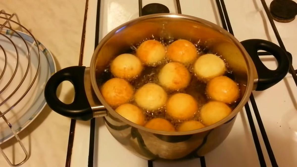 Обжаривание пончиков в кастрюле с маслом
