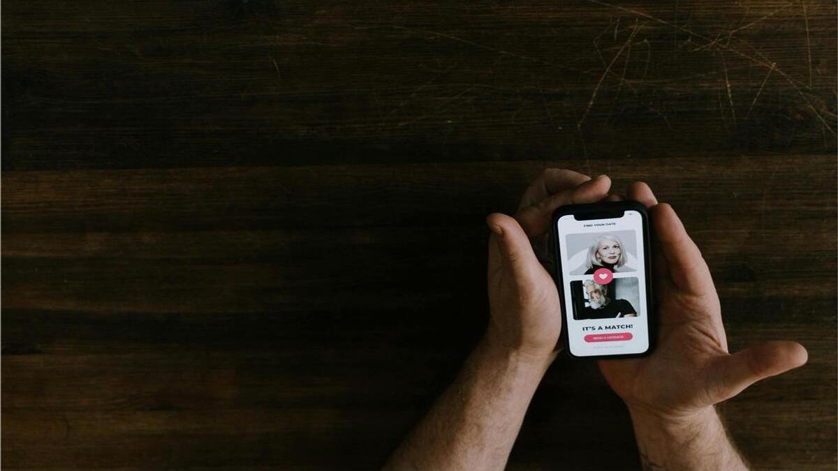 Мужчина держит в руках телефон с приложением для знакомств Мужчина держит в руках телефон с приложением для знакомств