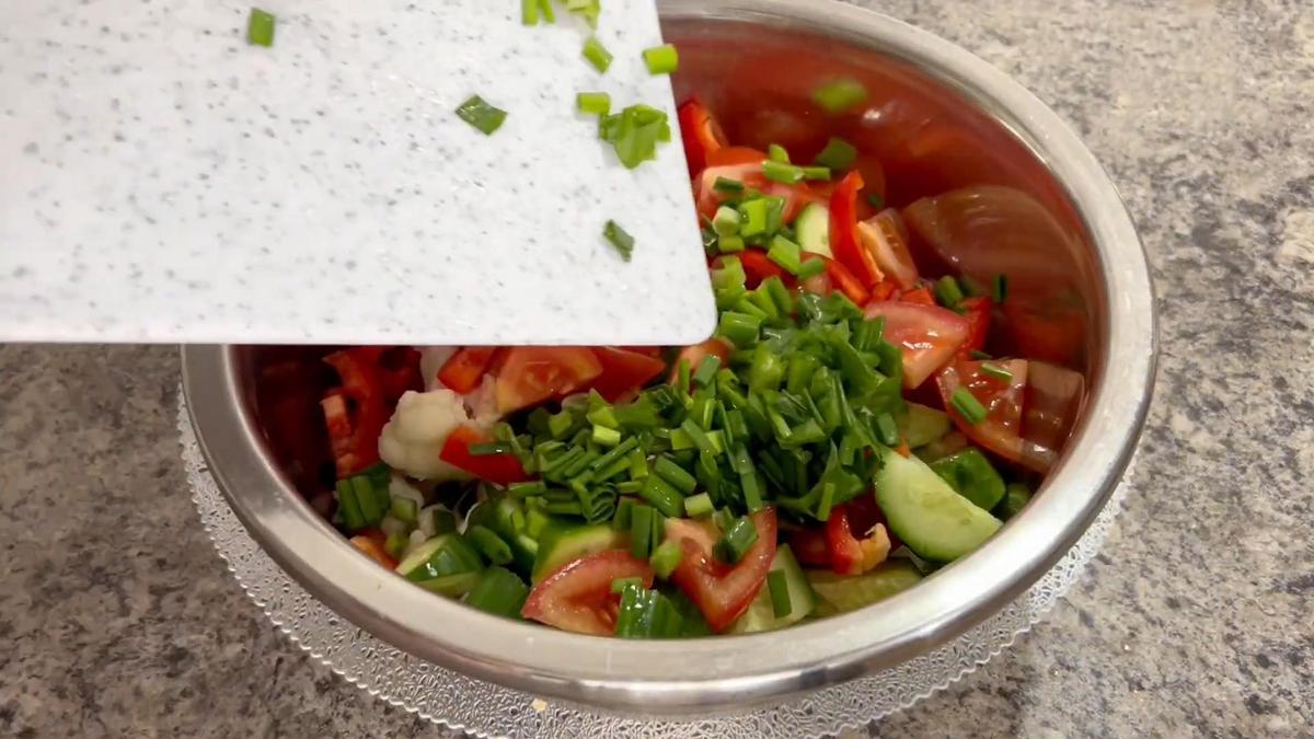В миску с нарезанными помидорам, огурцами и перцем кладут зеленый лук