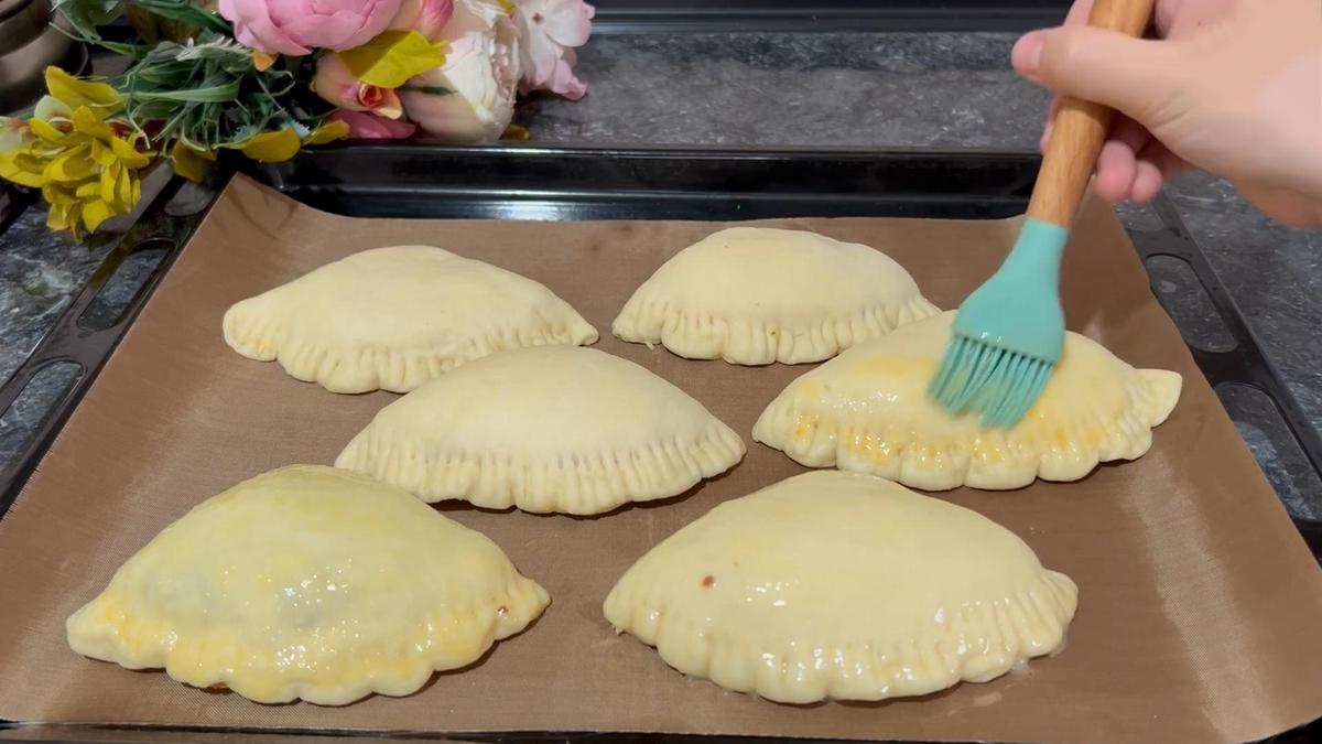 На противне заготовки пирожков смазывают желтком
