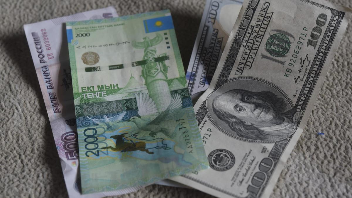 Купюра тенге лежит на долларах и рублях Купюра тенге лежит на долларах и рублях
