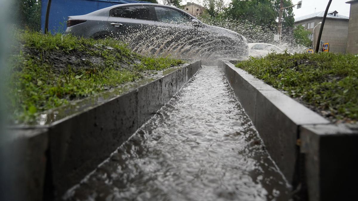 Вода разливается из луж при проезде машины