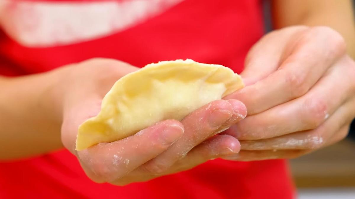 Девушка лепит руками вареник