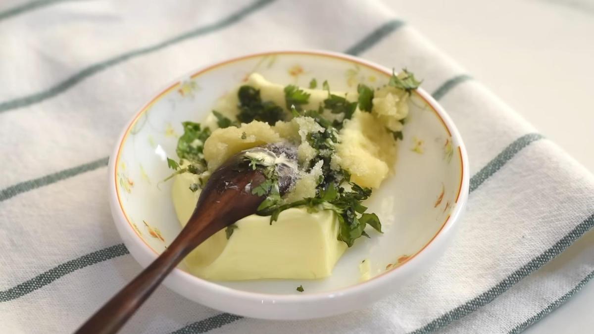 В блюдце мягкое сливочное масло, тертый чеснок и измельченная зелень