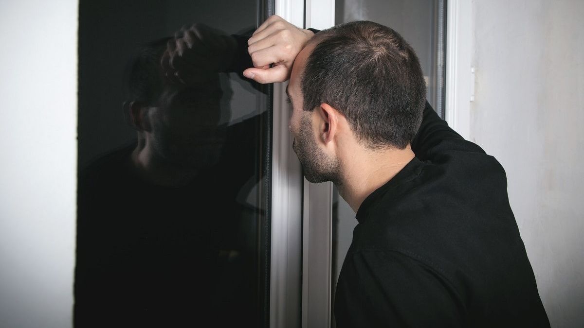 Мужчина смотрит в окно