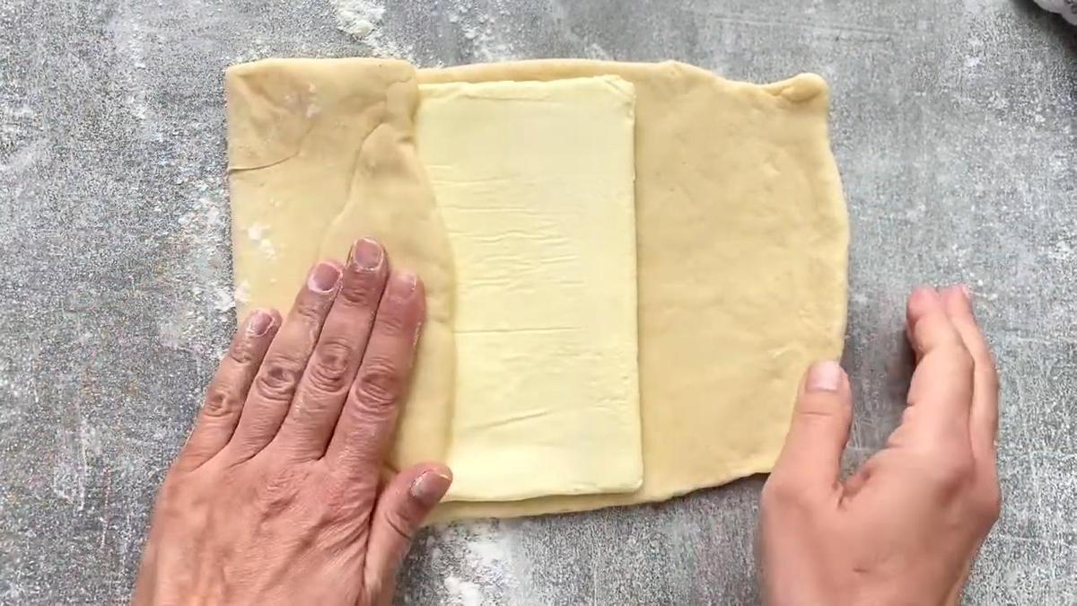 Квадратный слой масла укутывают тестом