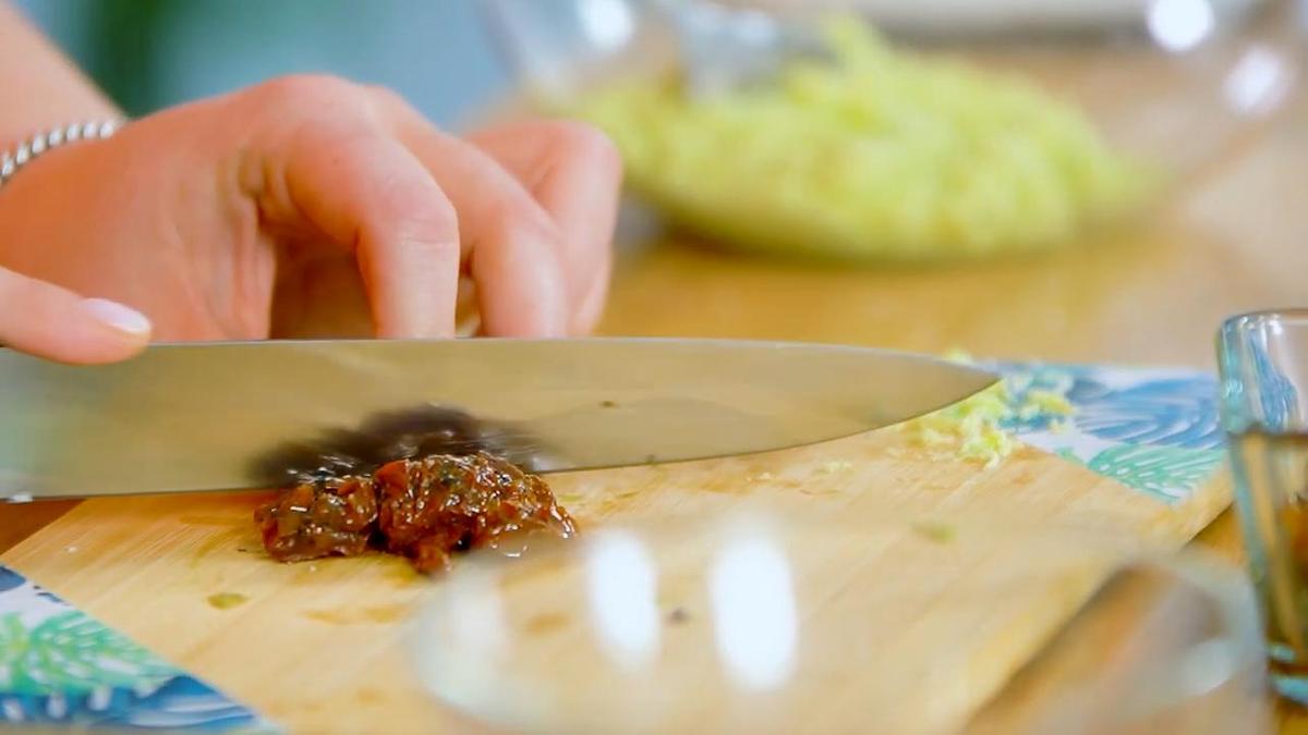 Вяленые томаты нарезают ножом на разделочной доске