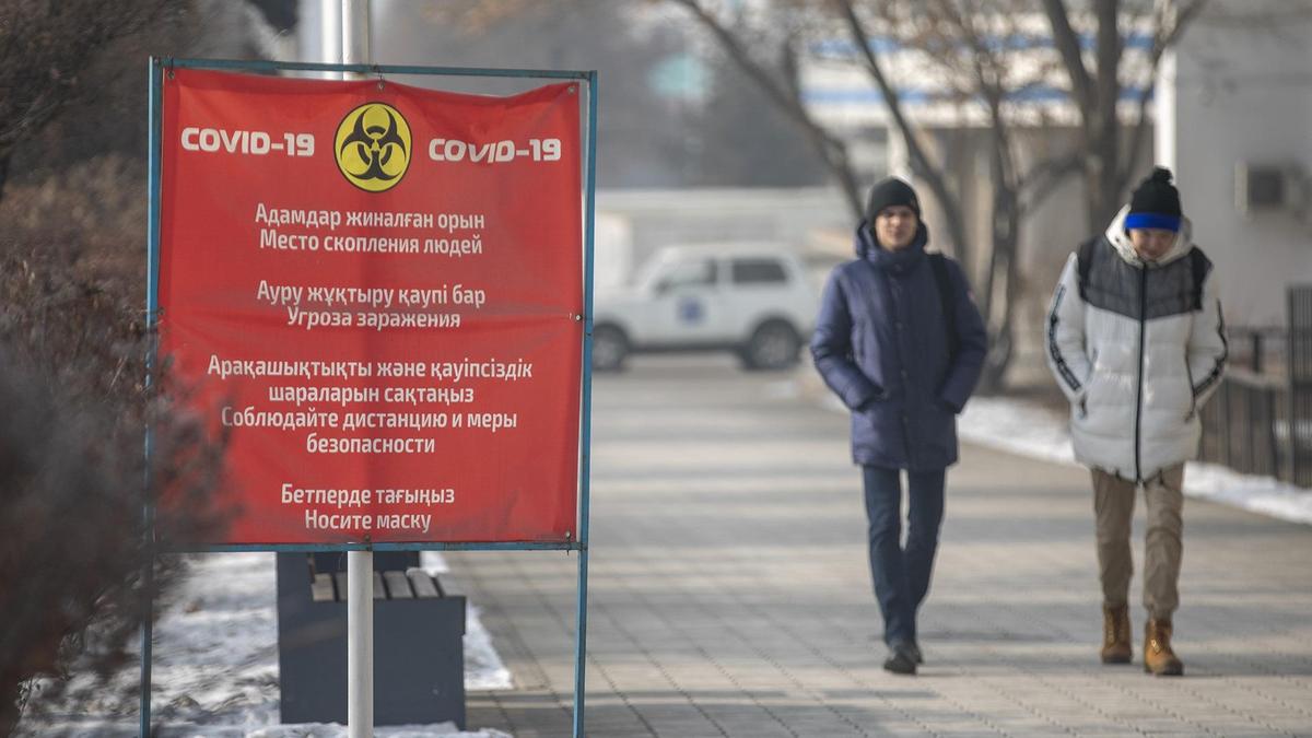 Люди в масках идут по улице Люди в масках идут по улице