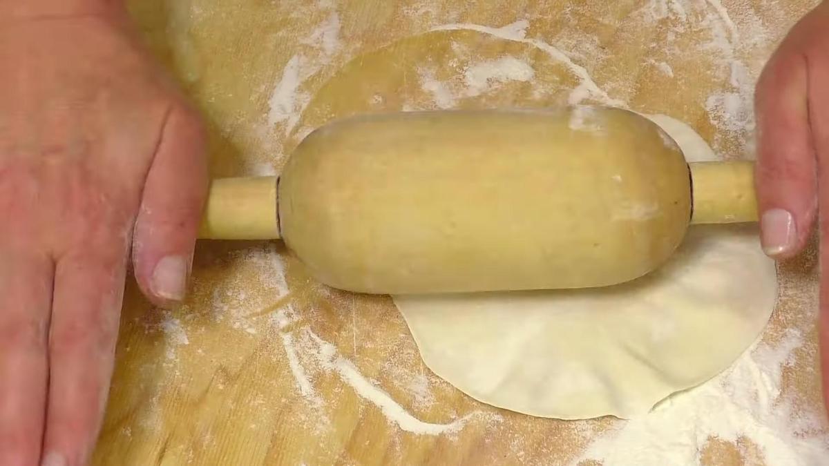 Раскатка теста скалкой на поверхности стола