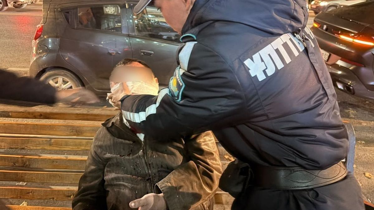 Ер адамға көмек көрсетіп жатқан сарбаз