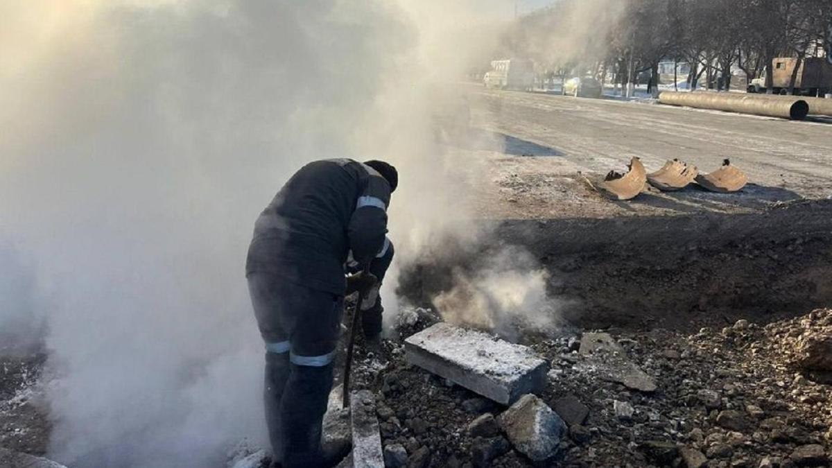 Екібастұзда жылу магистральдарын жөндеп жатқан маман