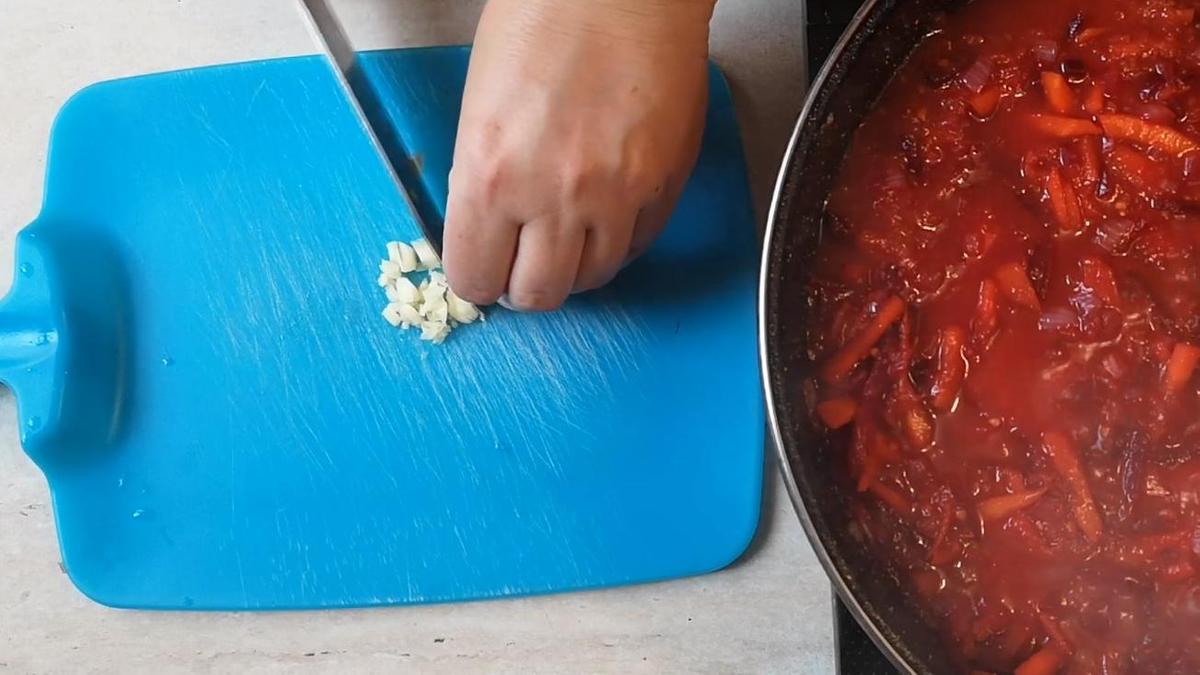 Нарезанный чеснок на синей доске