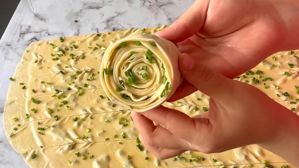 В руках заготовка из теста для лепешки каттама