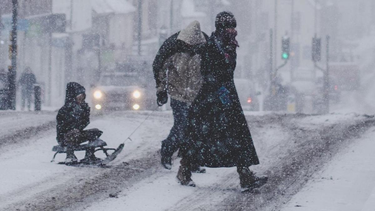 Люди переходят дорогу в метель