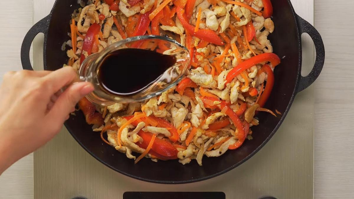 Соевый соус вливают в сковороду с мясом и овощами