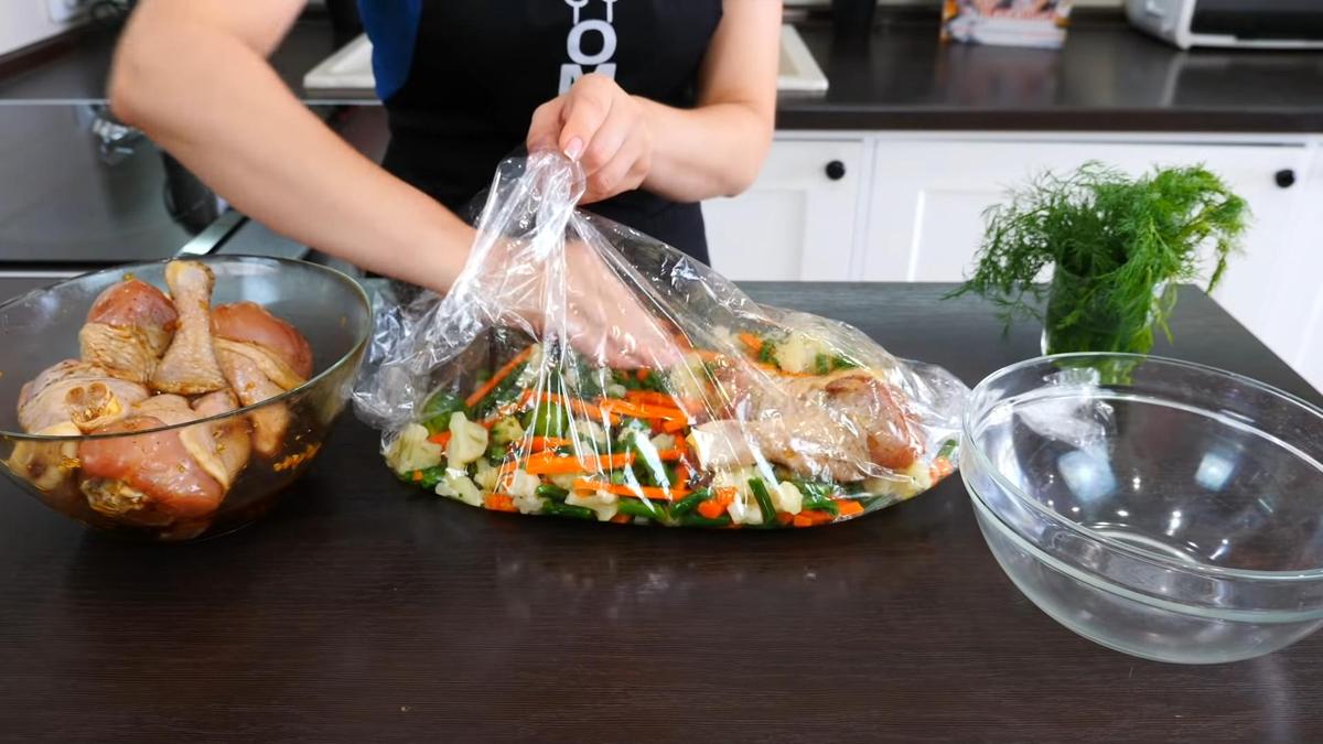 Куриные голени перекладывают из стеклянной миски в рукав для запекания