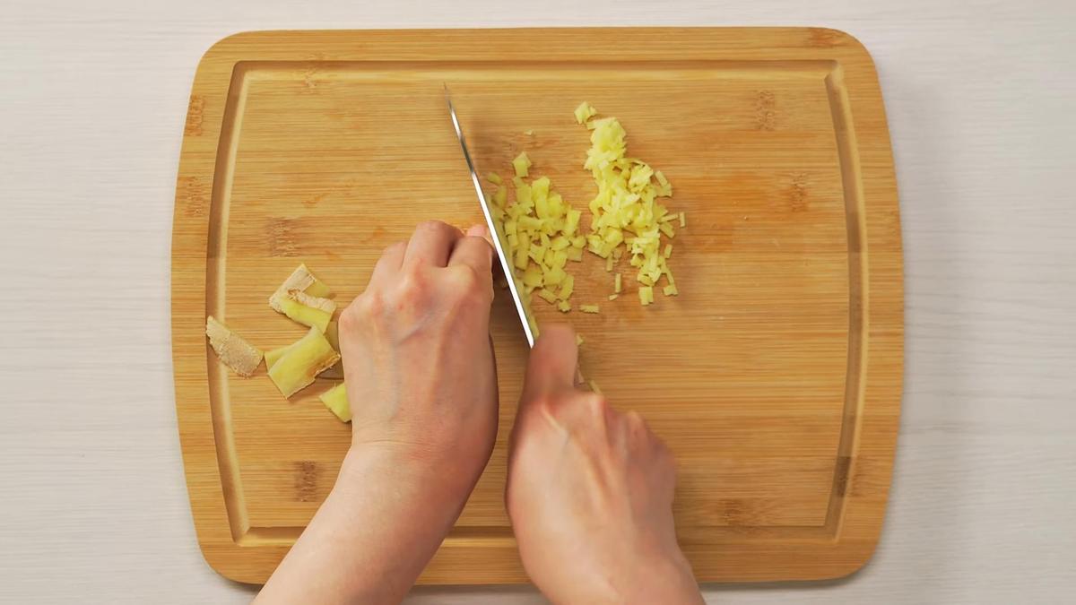 Имбирь режут мелким кубиком на разделочной доске