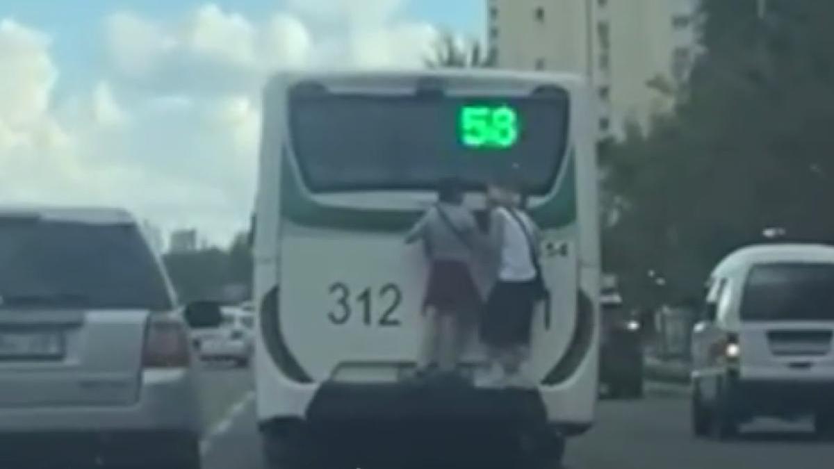 Подростки катаются на заднем бампере автобуса