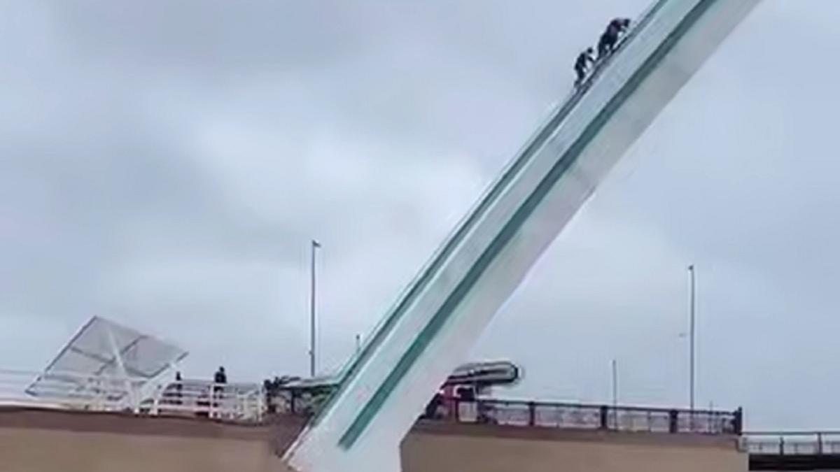 Мужчина и спасатели на арке моста Мужчина и спасатели на арке моста