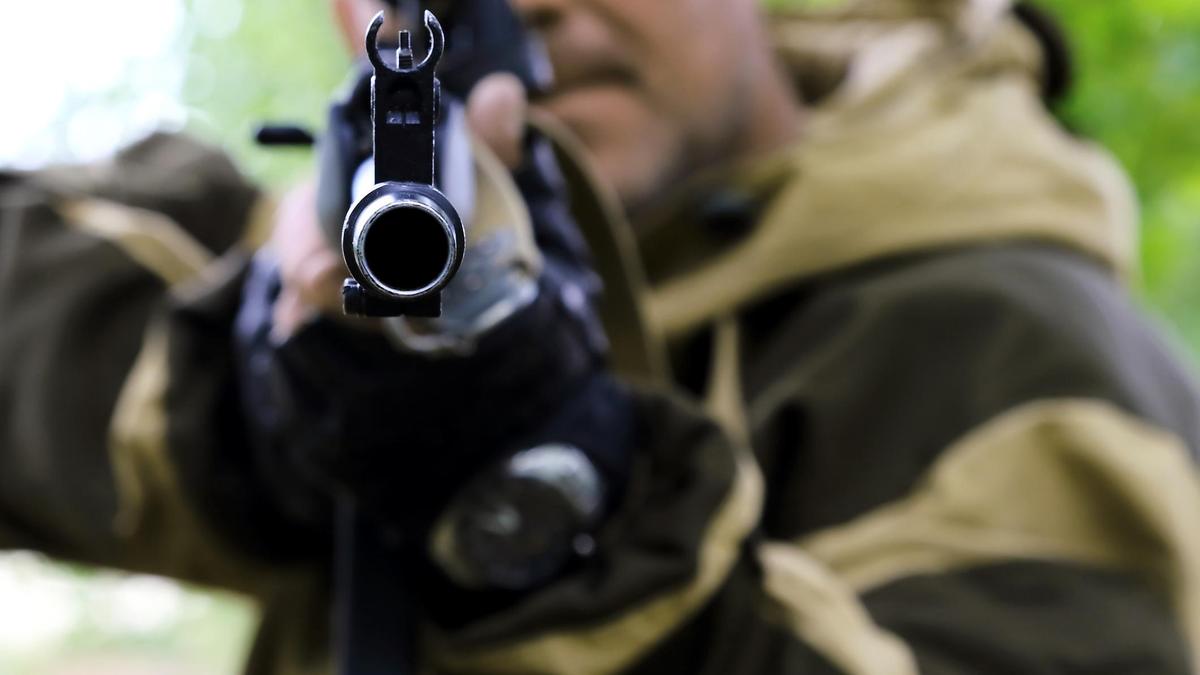 Мужчина держит в руках ружье