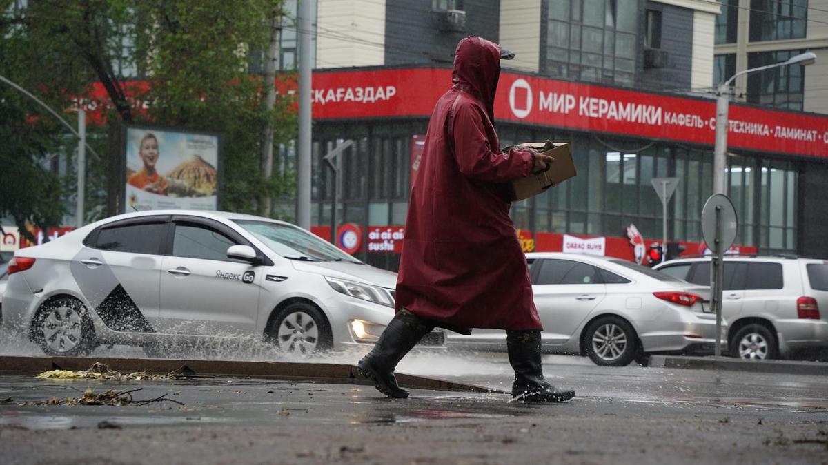 Жаңбырлы күні көшеде кетіп бара жатқан ер адам