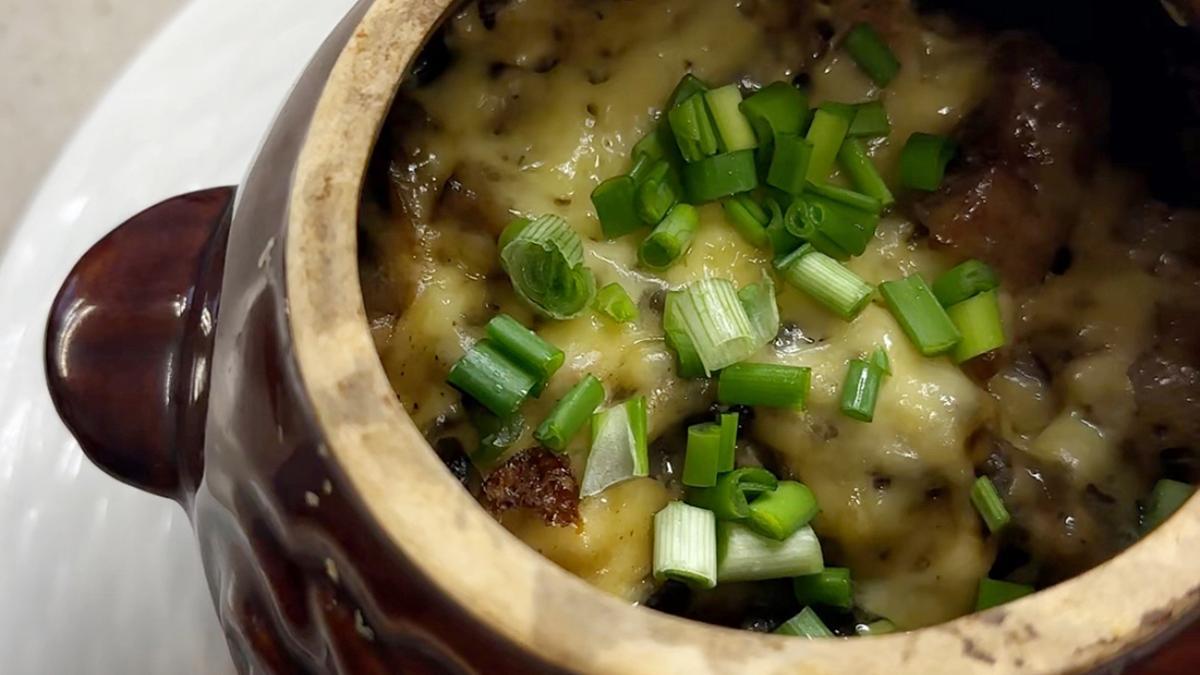 В глиняном горшочке мясо с грибами, сыром, овощами и свежей зеленью