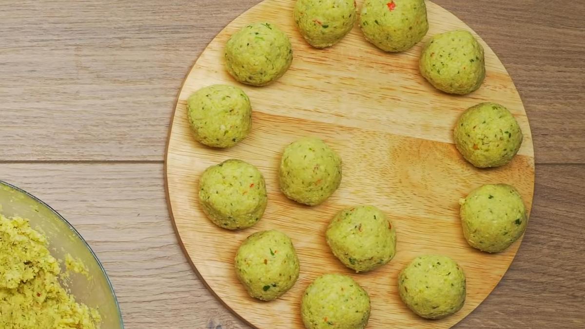 Сырые шарики фалафеля на круглой деревянной доске