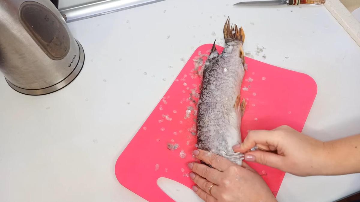 Очистка щуки от чешуи на разделочной доске