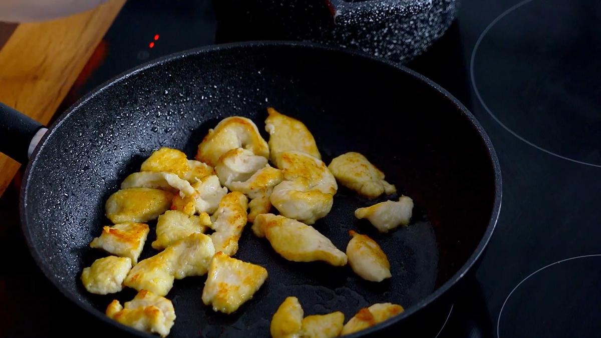 На сковороде обжаренное куриное филе
