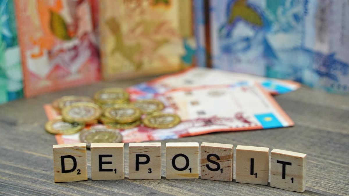 Кубики с надписью "Deposit" стоят на фоне денег