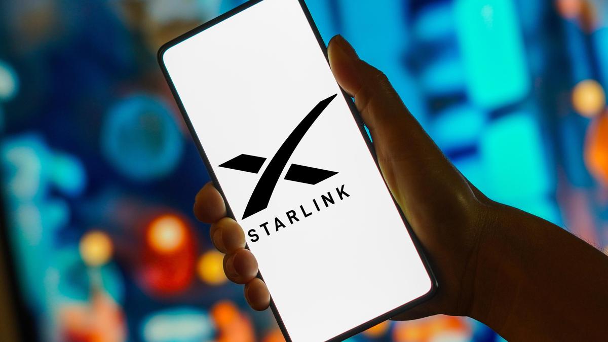 Человек держит смартфон с логотипом Starlink