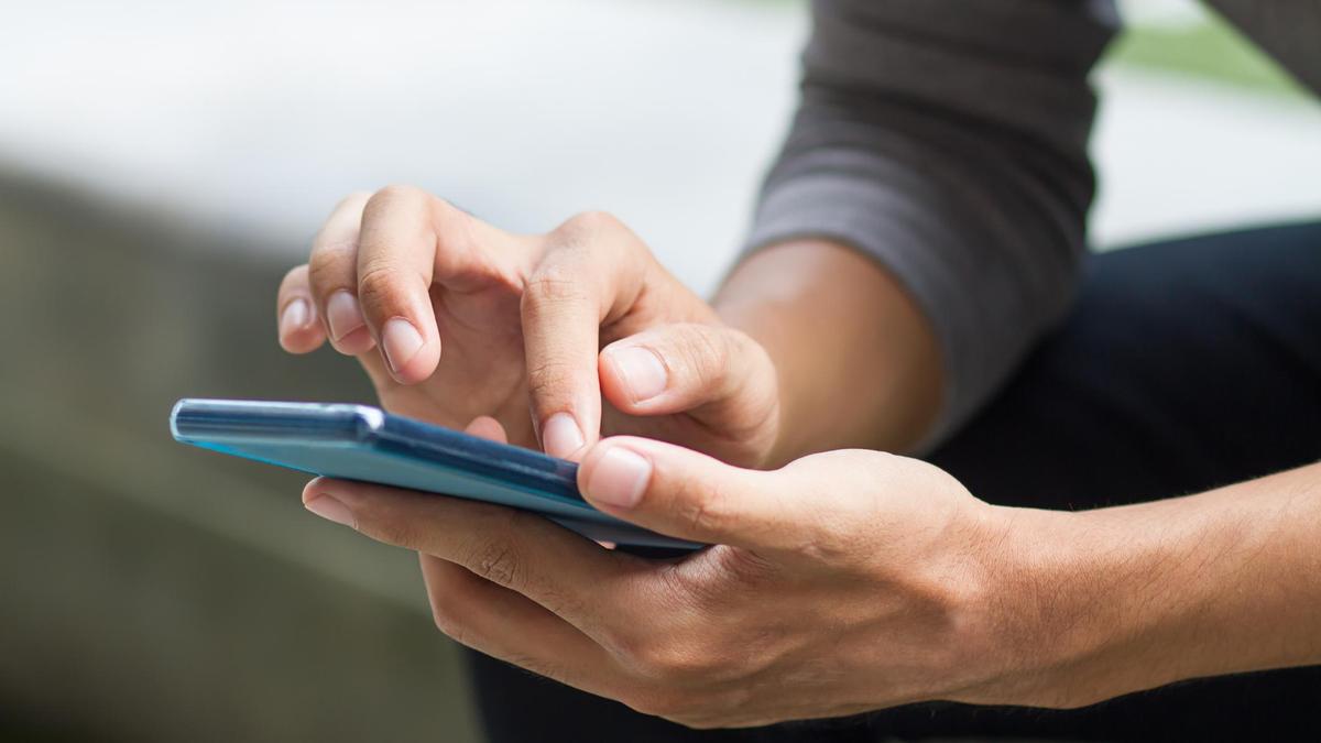 Телефон ұстаған ер адам