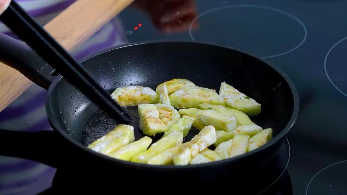 Кусочки баклажан жарятся на сковороде