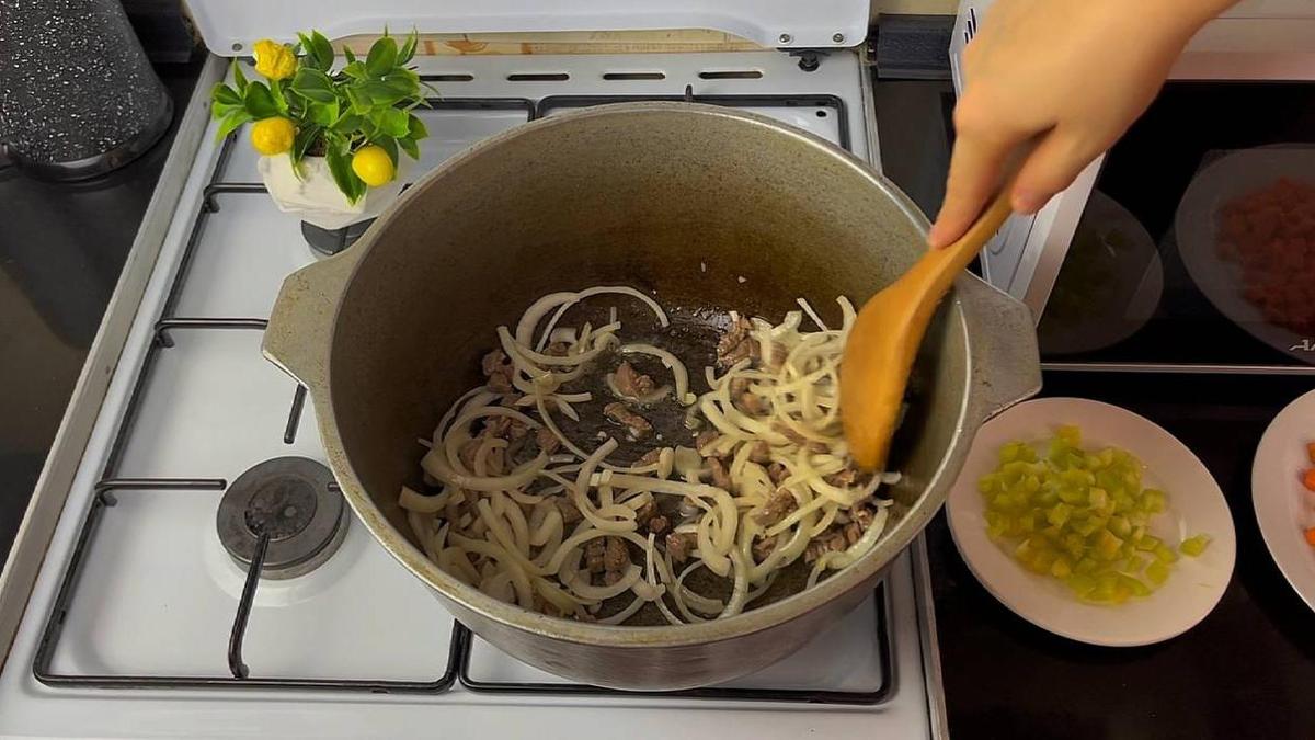 В казане перемешивают говядину и репчатый лук