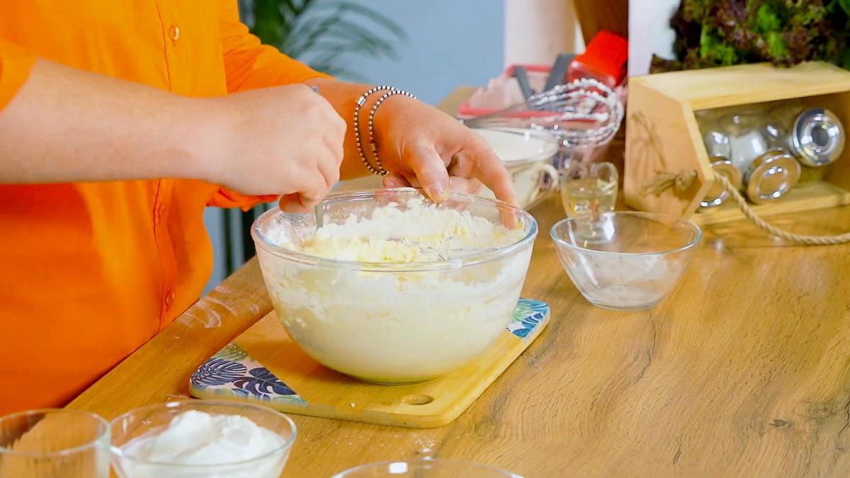 Девушка вмешивает муку в тесто