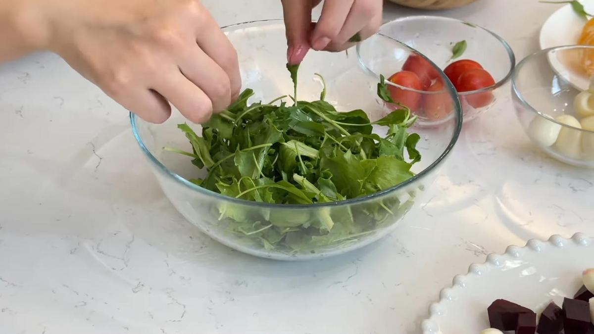 В глубокой миске перемешивают листья свежей рукколы