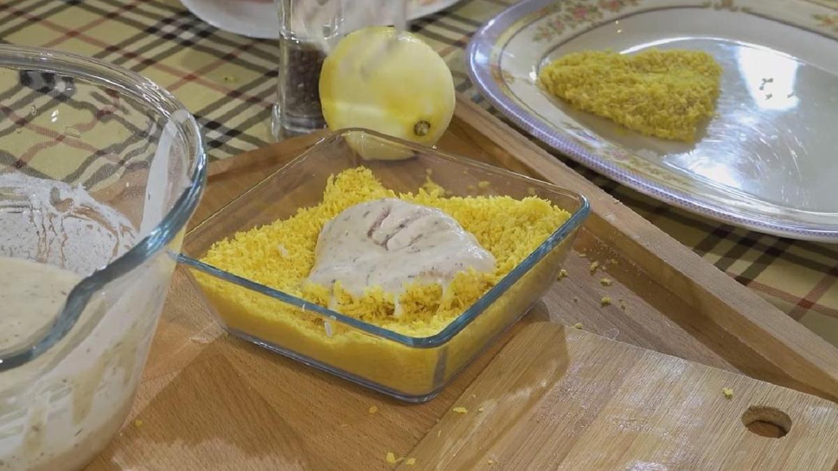 Смоченная кляром котлета лежит в панировке