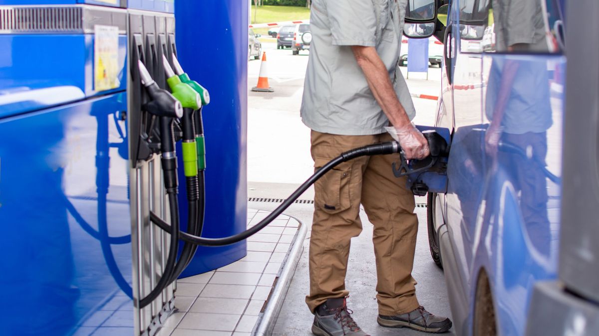 Мужчина заправляет машину на АЗС