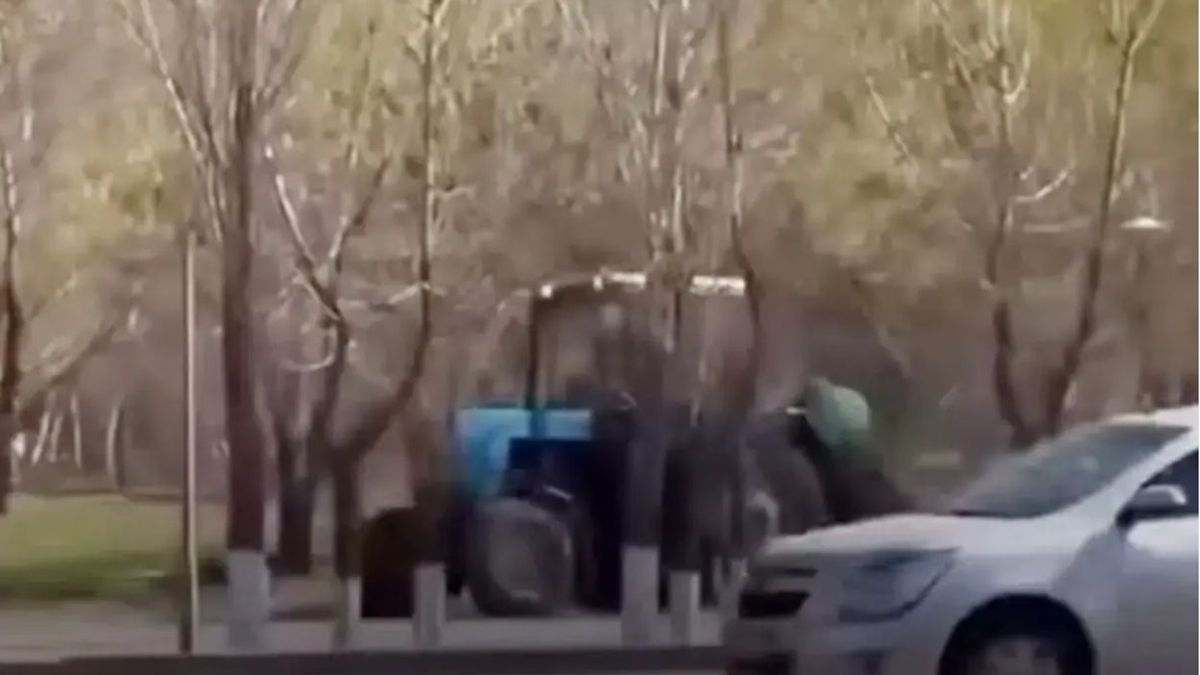 Тротуармен кетіп бара жатқан трактор