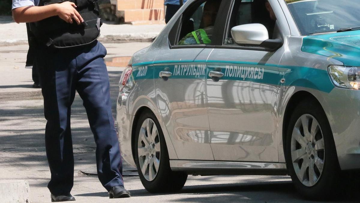 Полицейский стоит рядом со служебным авто Полицейский стоит рядом со служебным авто