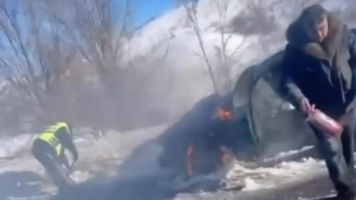 Полицейский тушит загоревшийся автомобиль Полицейский тушит загоревшийся автомобиль